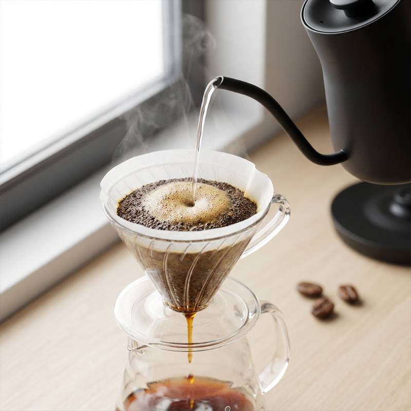 A barista expertly pouring milk to create latte art in a ceramic mug.